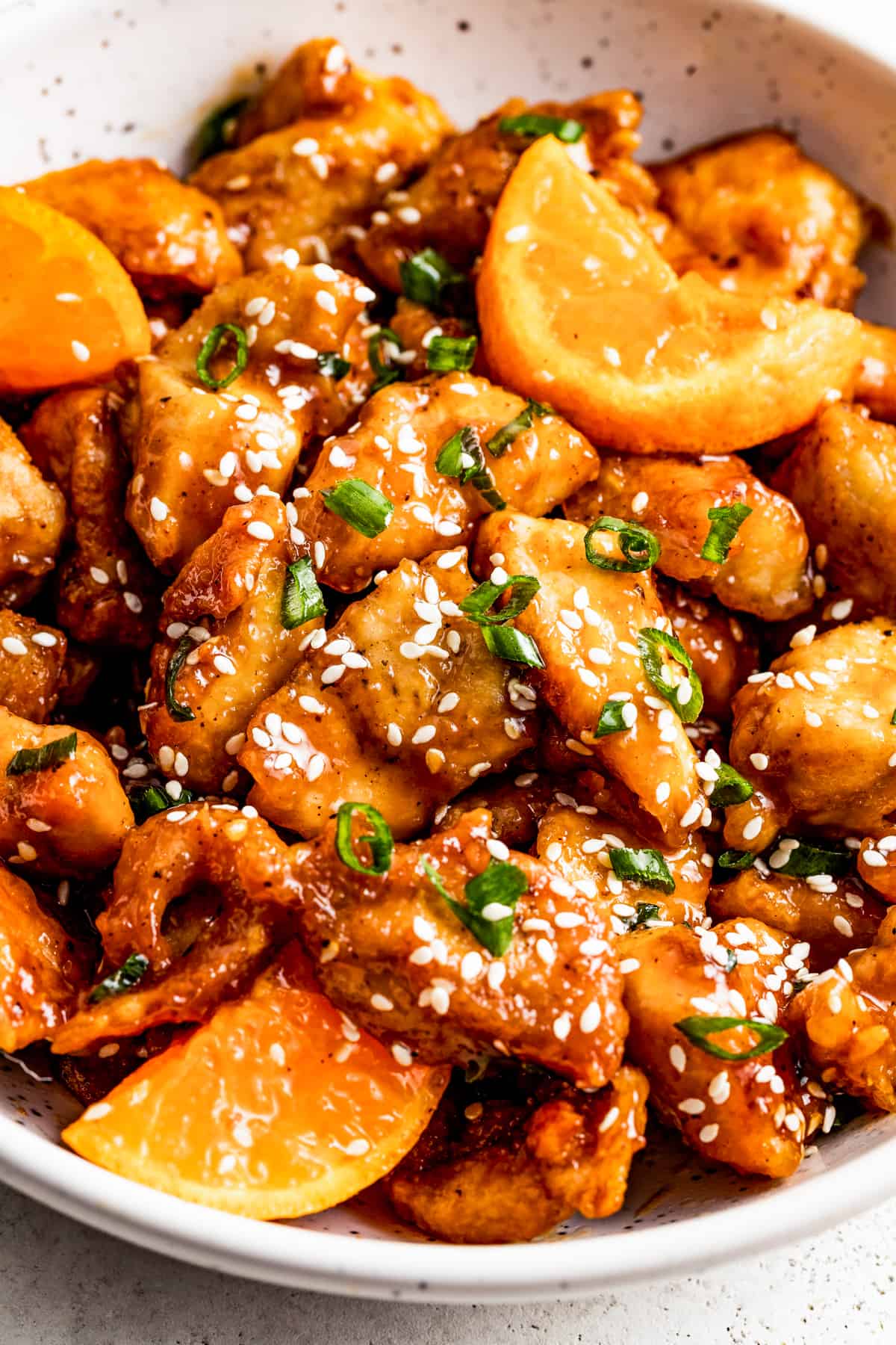 bowl with mandarin chicken and a garnish of sesame seeds over the chicken pieces.