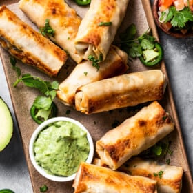Homemade egg rolls with an avocado crema on the side.
