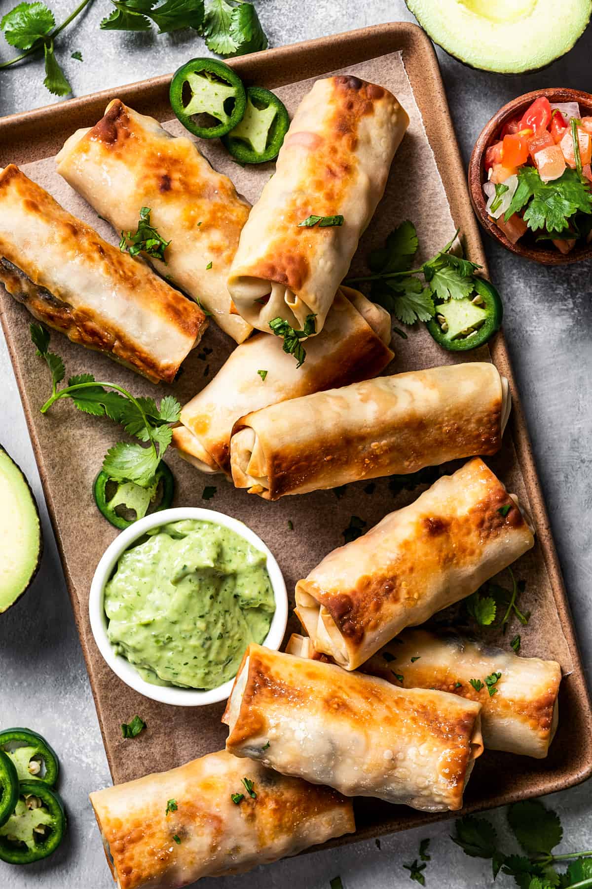 Homemade egg rolls with an avocado crema on the side.
