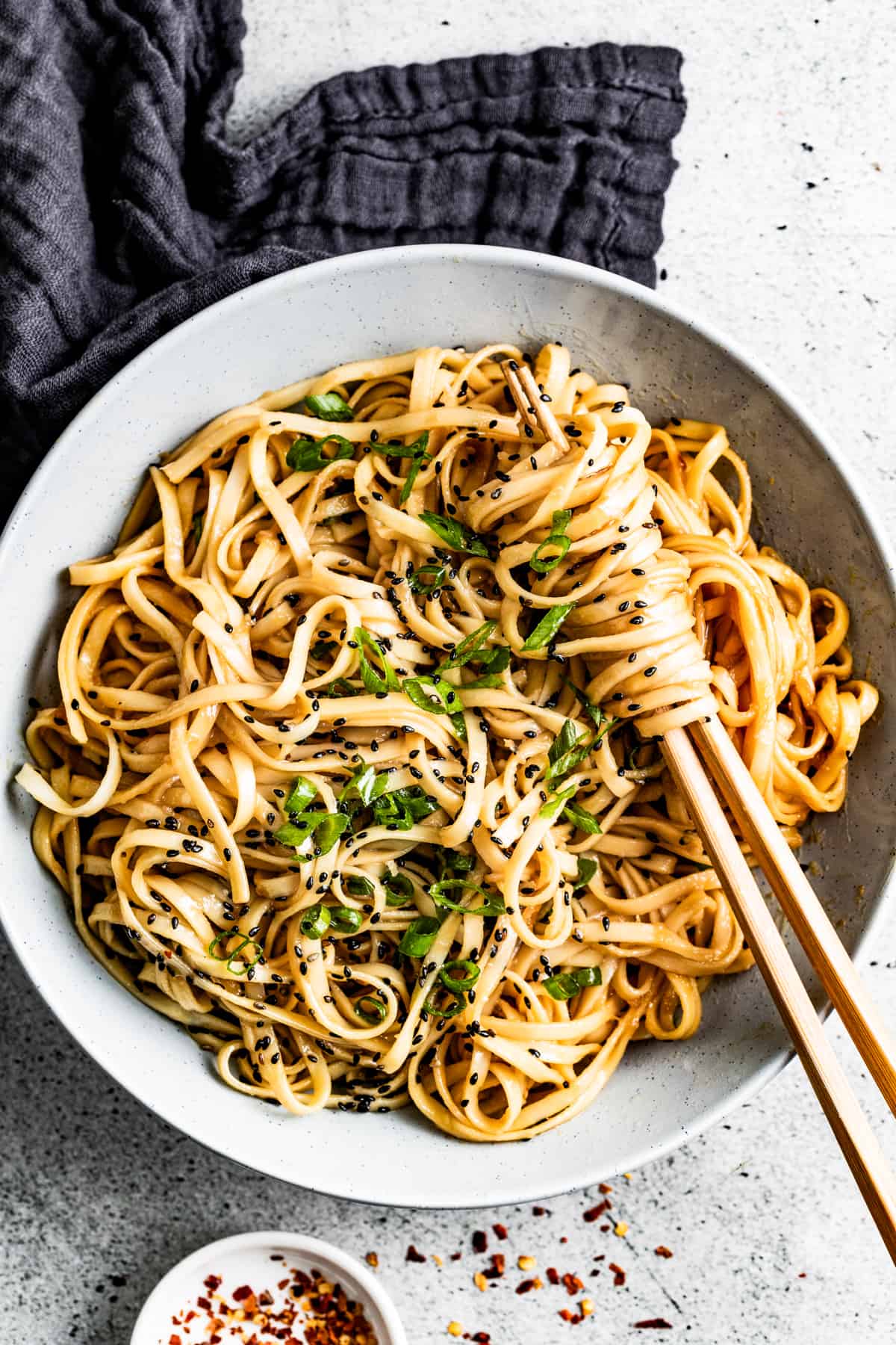 Easy teriyaki noodles in a bowl sprinkled with green onions and sesame seeds.