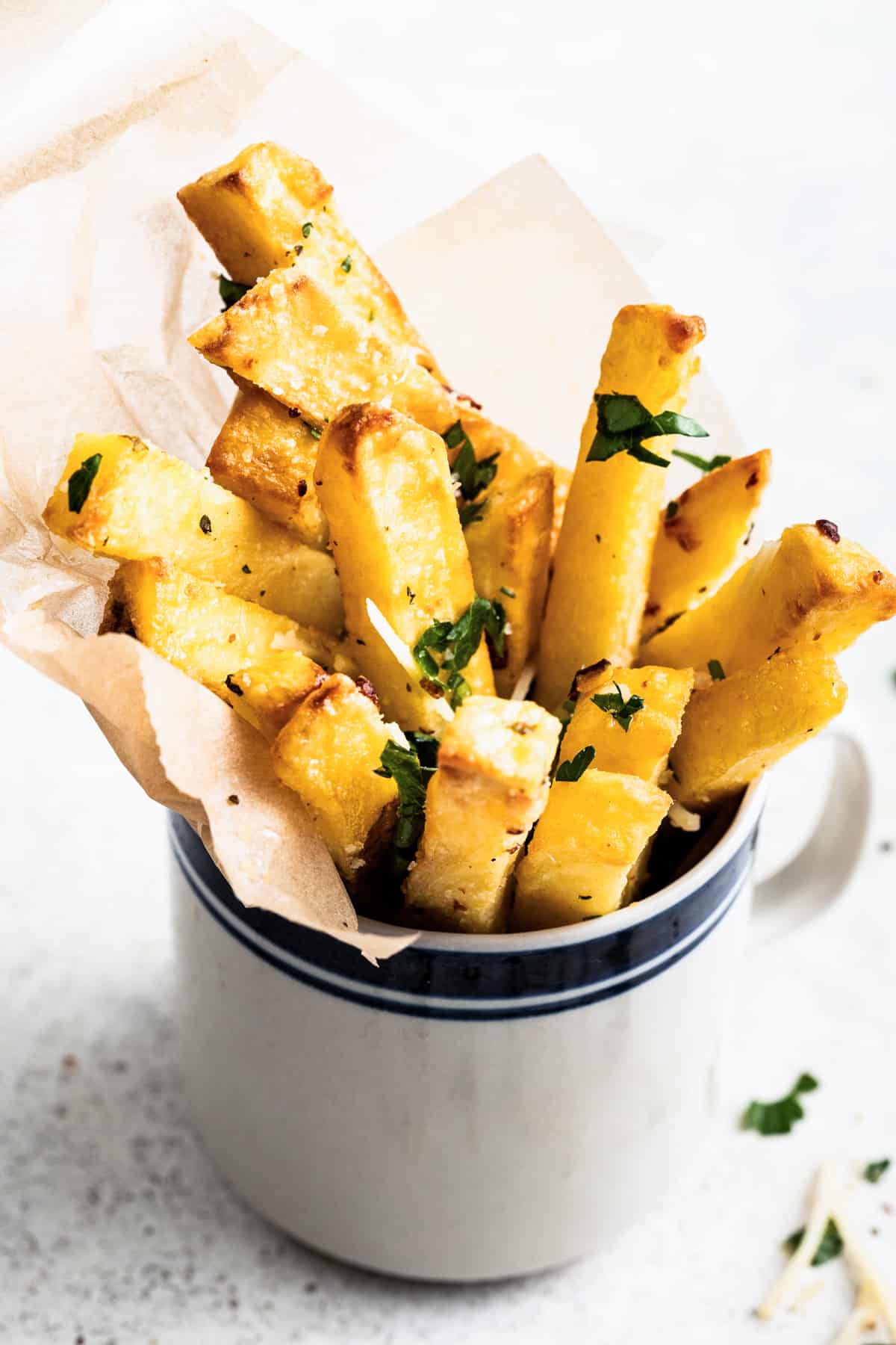 Parmesan truffle fries in a cup lined with parchment paper.