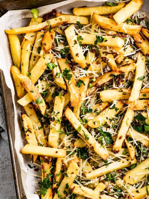 Shot of baked truffle fries garnished with chopped parsley.