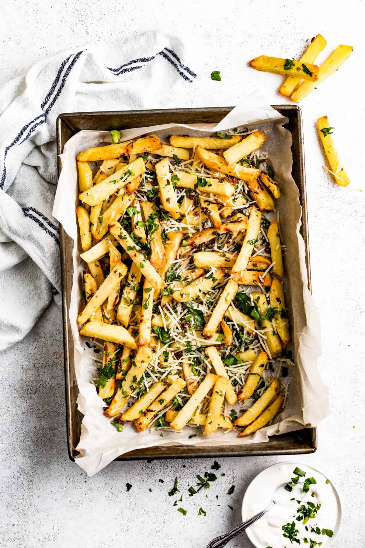 Parmesan truffle fries in a baking pan lined with parchment paper.