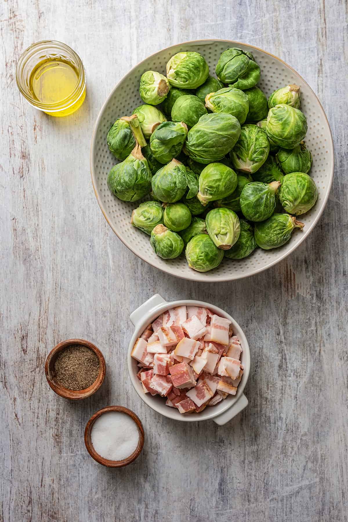 Ingredients for Brussels sprouts and bacon separated into bowls.