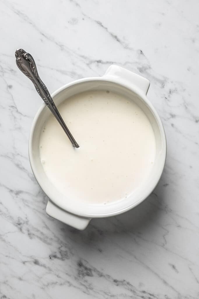 Creamy ranch drizzle in a bowl with a spoon.