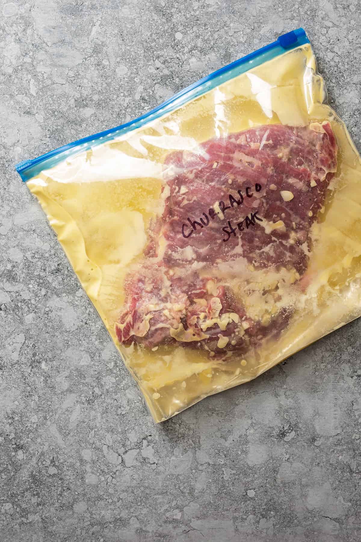 Marinating churrasco steak in a Ziplock bag.