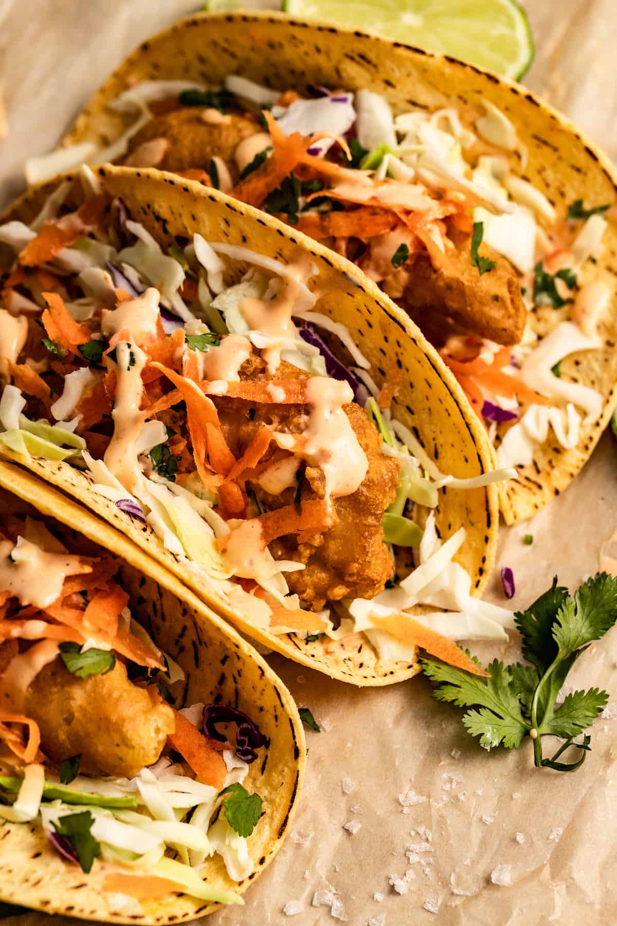 With a homemade batter and lots of toppings, these mahi mahi fish tacos are the coastal twist your regular tacos were missing. Three tacos stuffed with fried fish and coleslaw.