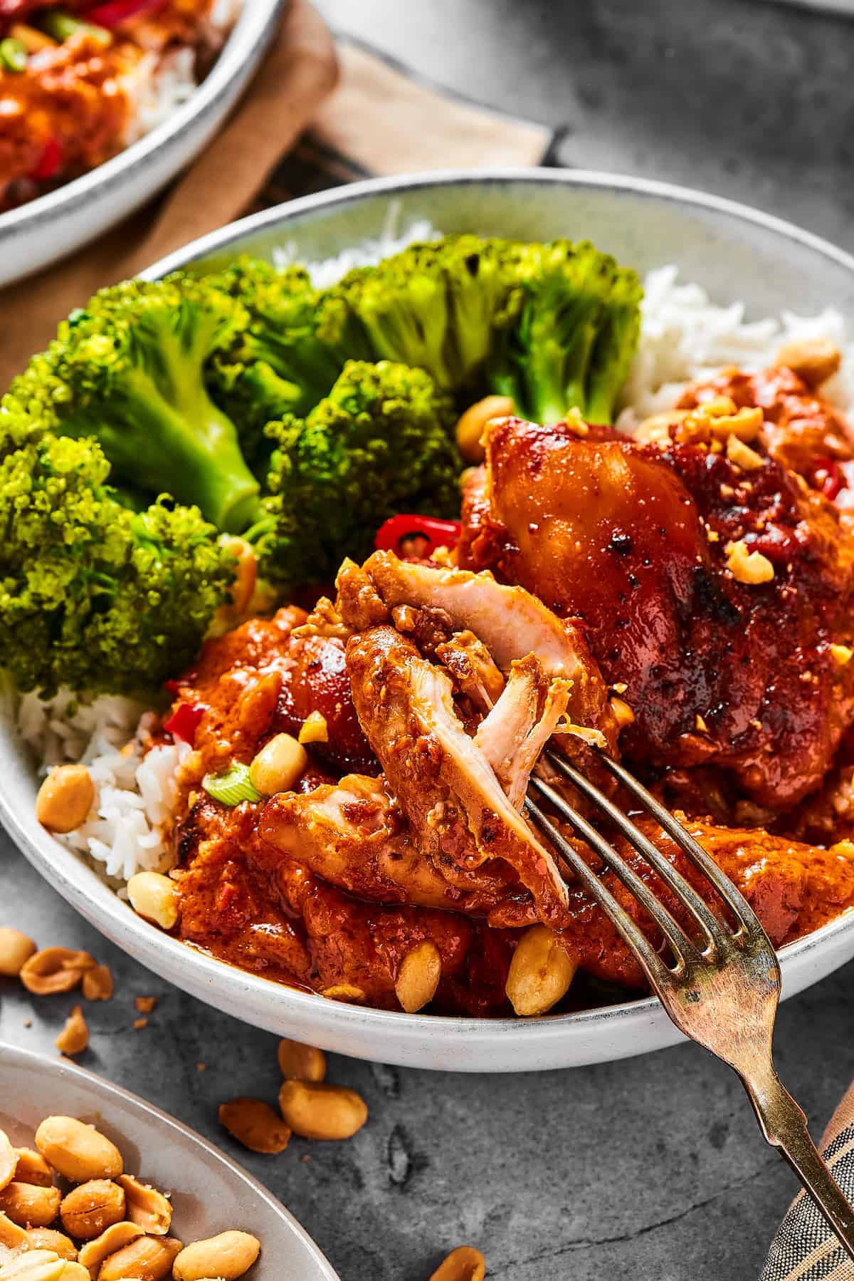 peanut butter chicken served on a plate with broccoli.