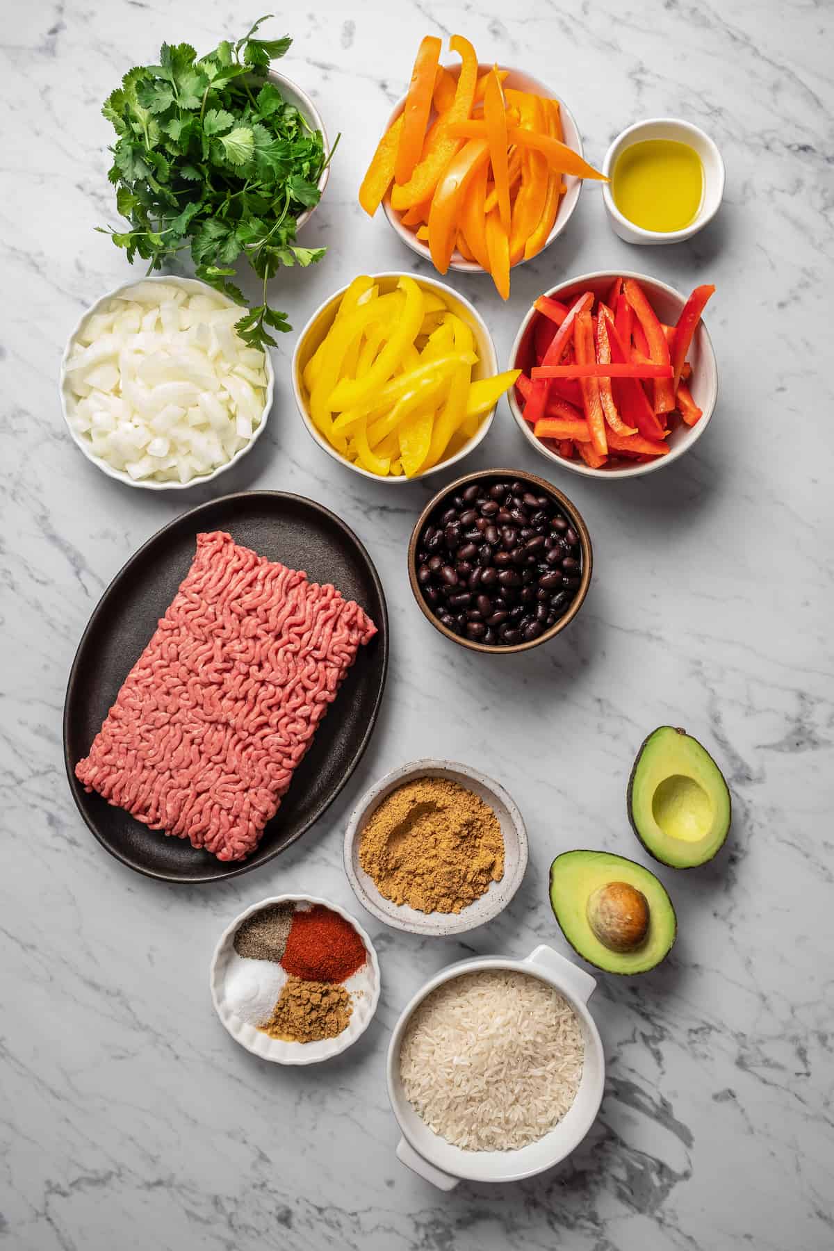 Ingredients for taco bowls separated into bowls.