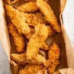 Air fryer chicken tenders in a paper-lined container.