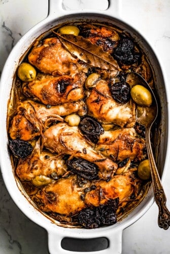 overhead shot of caramelized chicken Marbella in a baking dish.