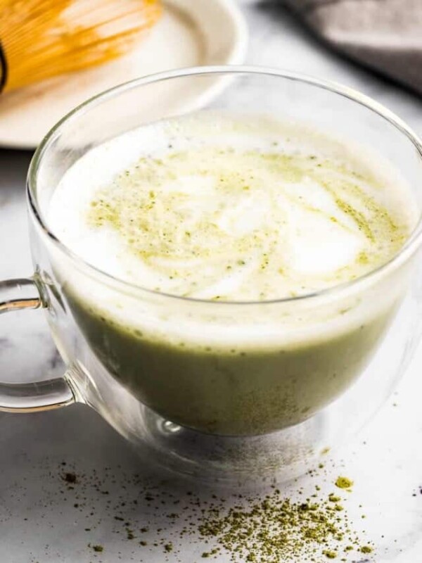 Warm matcha latte in a clear glass mug.