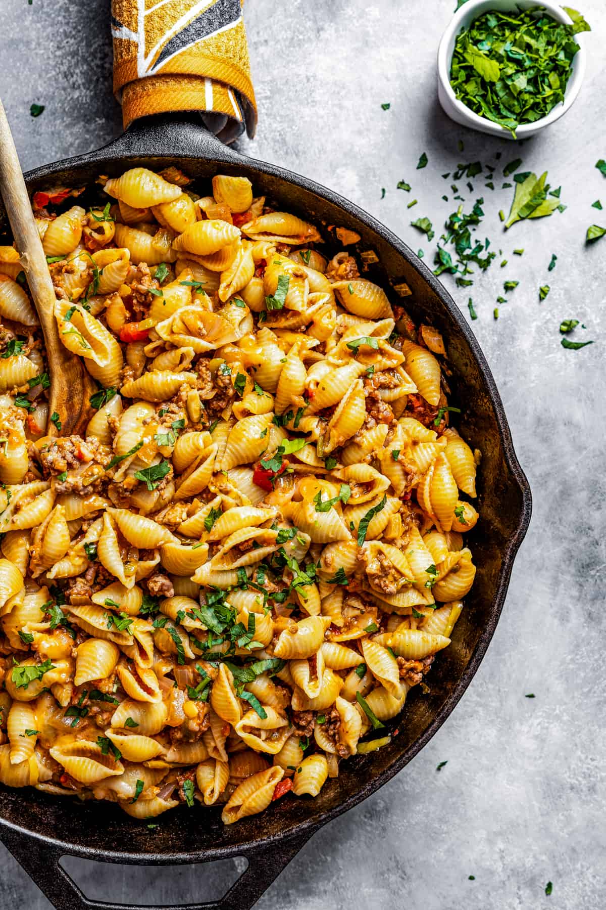 Taco pasta in a skillet with a wooden spoon.