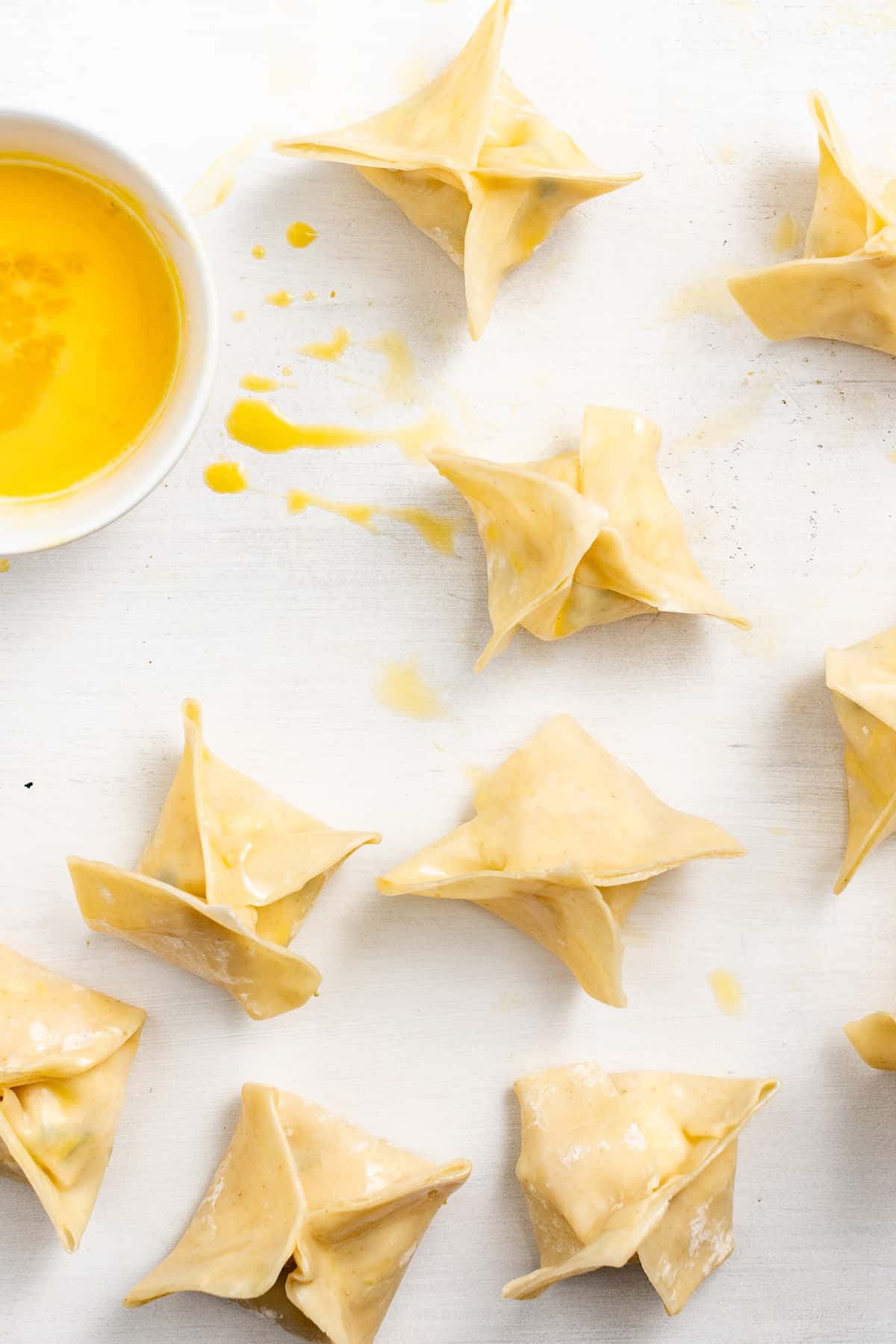 Sealing crab rangoon with egg wash.