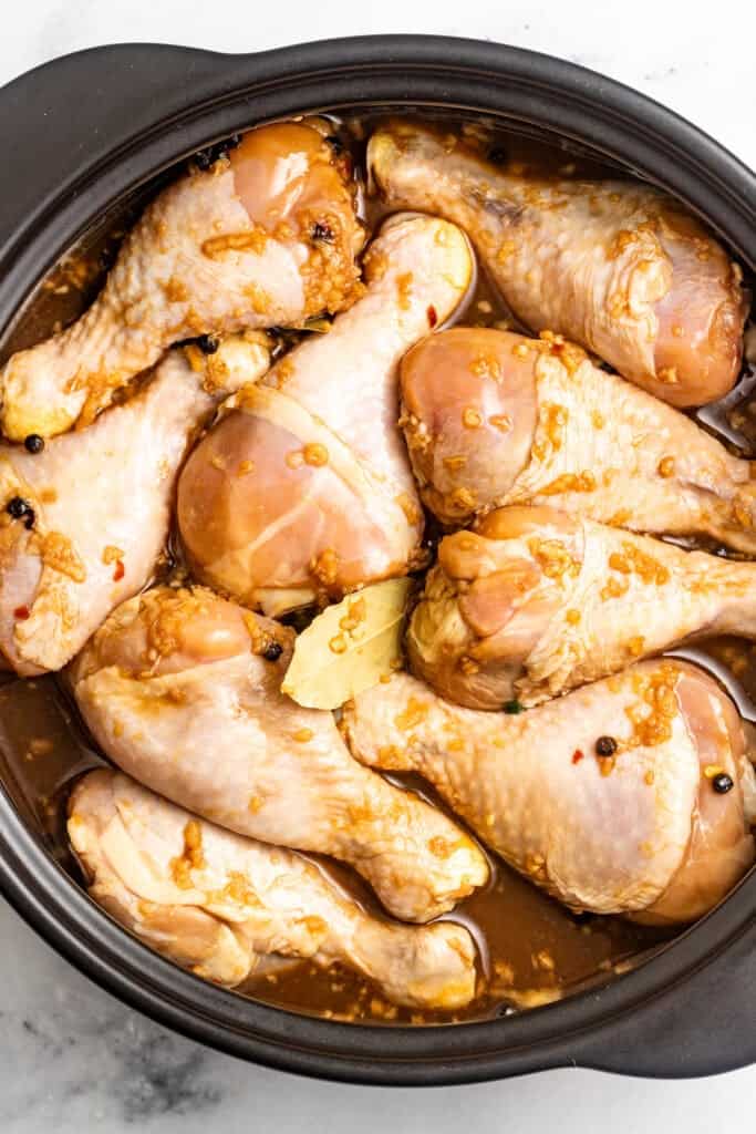 Simmering chicken adobo in a pan.