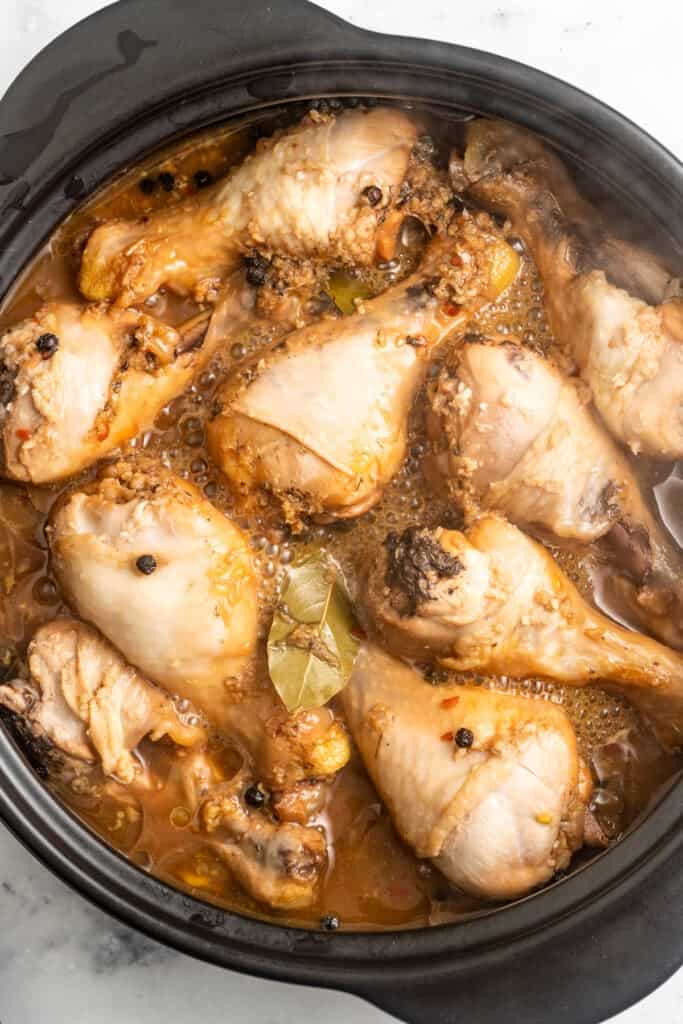 Simmering chicken adobo in a saucepan.