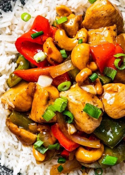 Close up overhead view of a plate of cashew chicken served on rice.