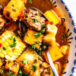 Sancocho Dominicano in a bowl with a spoon.