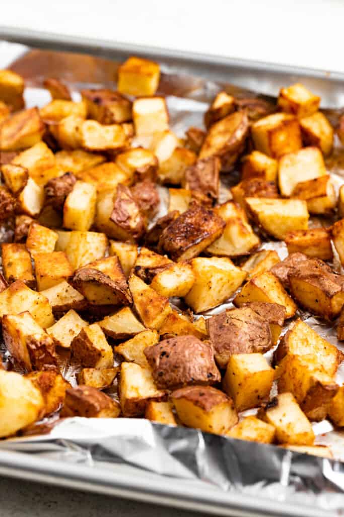 Roasted potatoes on a baking sheet lined with aluminum foil.