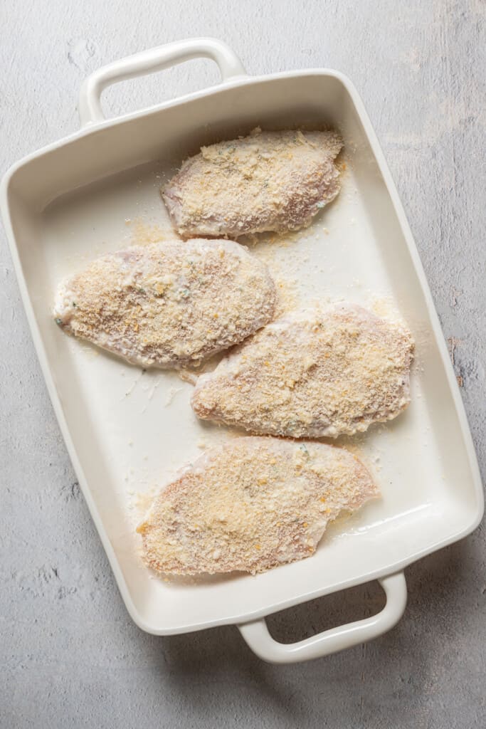 Marinated chicken on a baking sheet ready to bake.