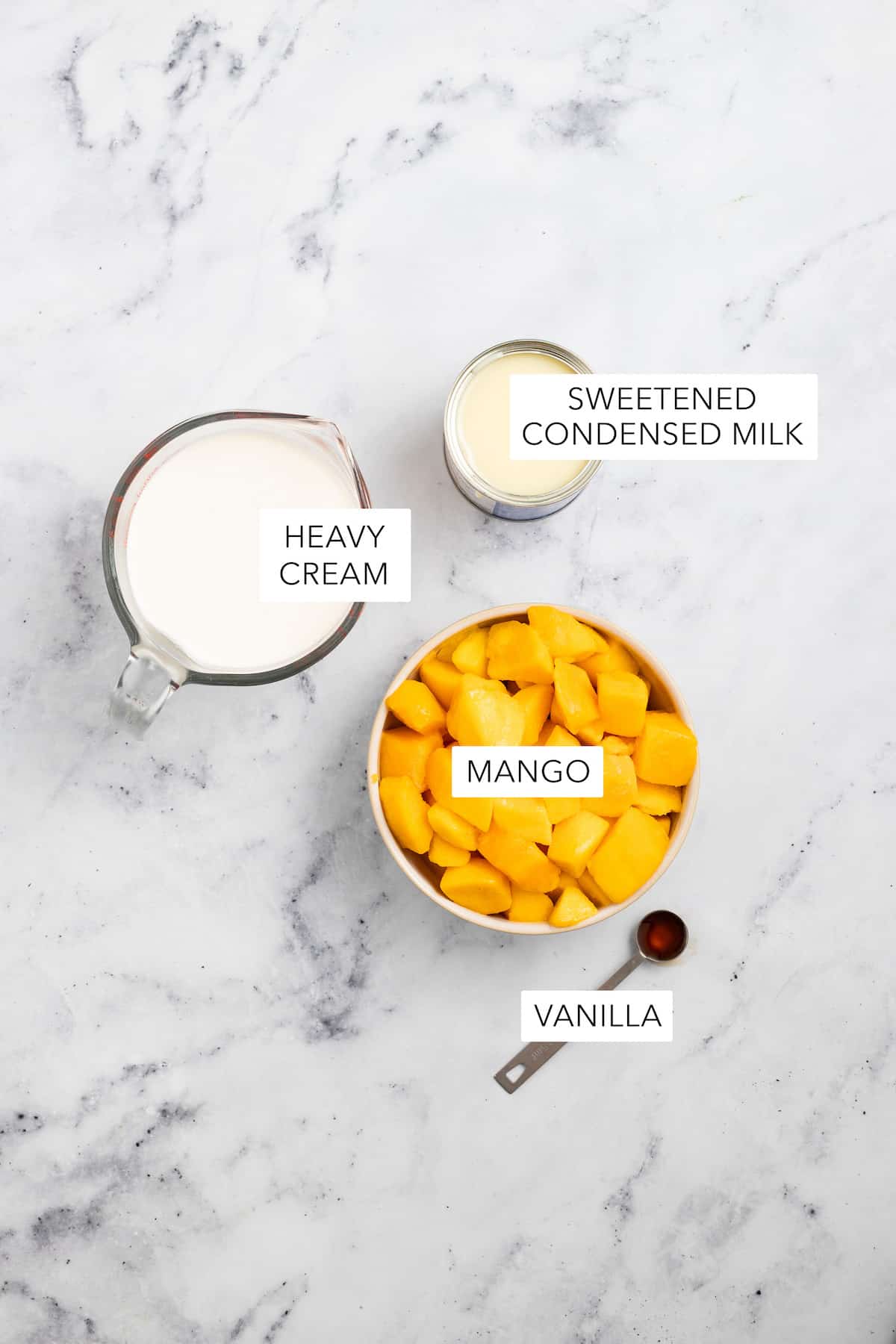 Ingredients for mango ice cream separated and labeled.