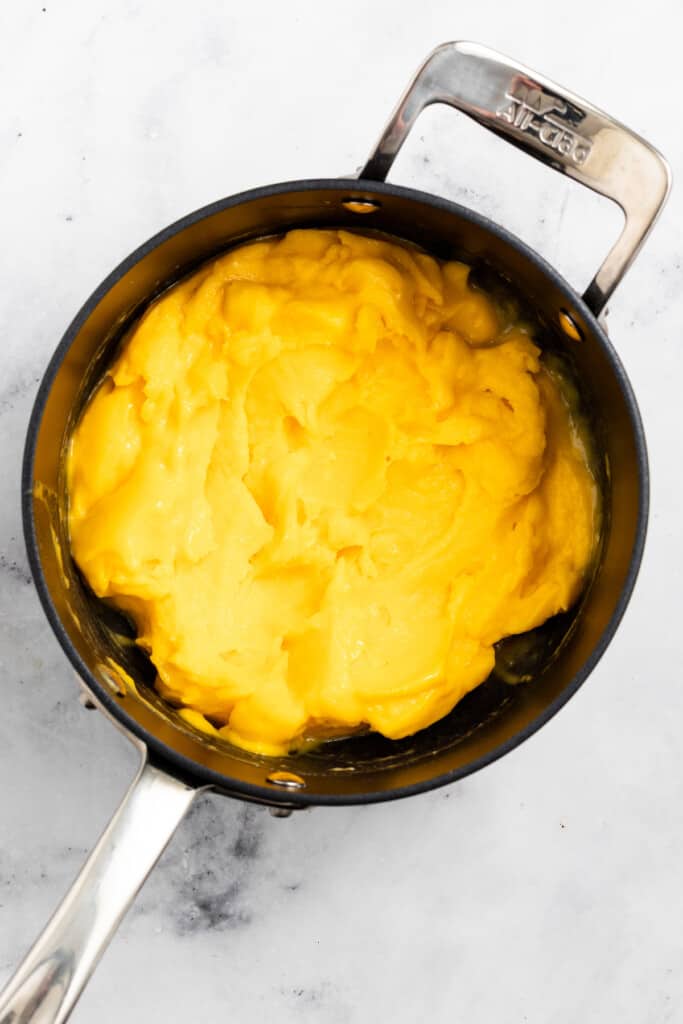 Reducing mango puree in a saucepan.