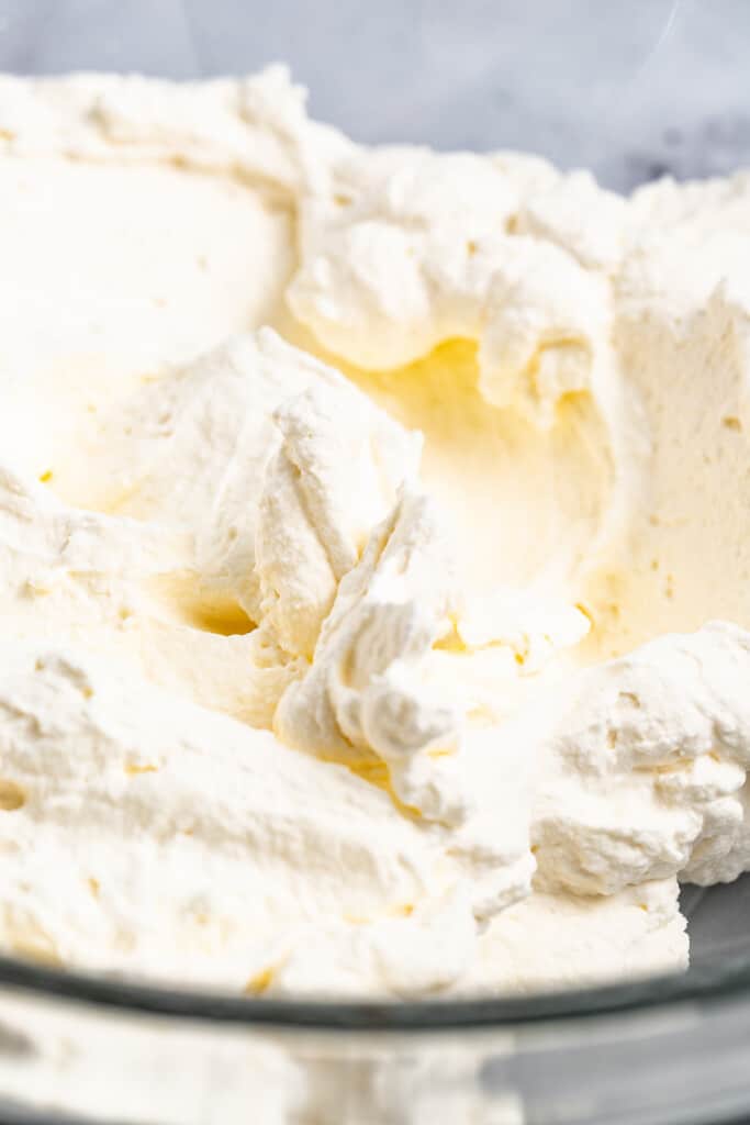 Closeup of whipped cream in a mixing bowl.