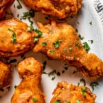 Close-up shot of beer-battered chicken drumsticks arranged on a serving plate.