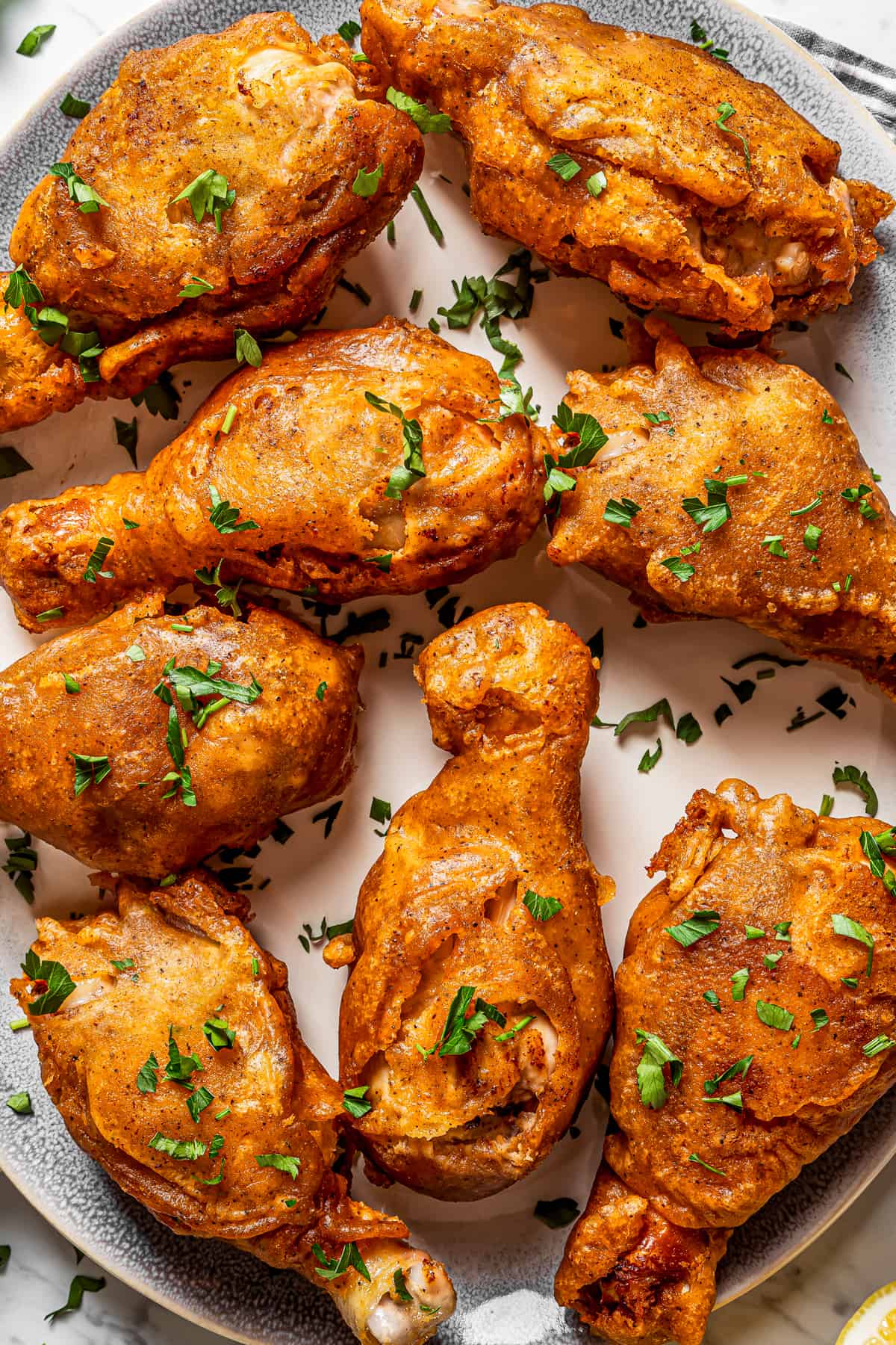 Overhead close-up shot of beer-battered chicken arranged on a serving plate.