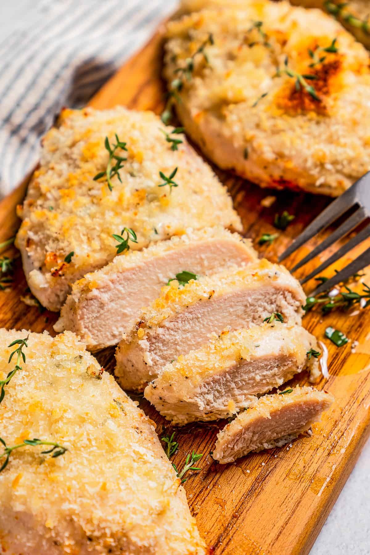 Sliced breaded chicken breasts on a cutting board.