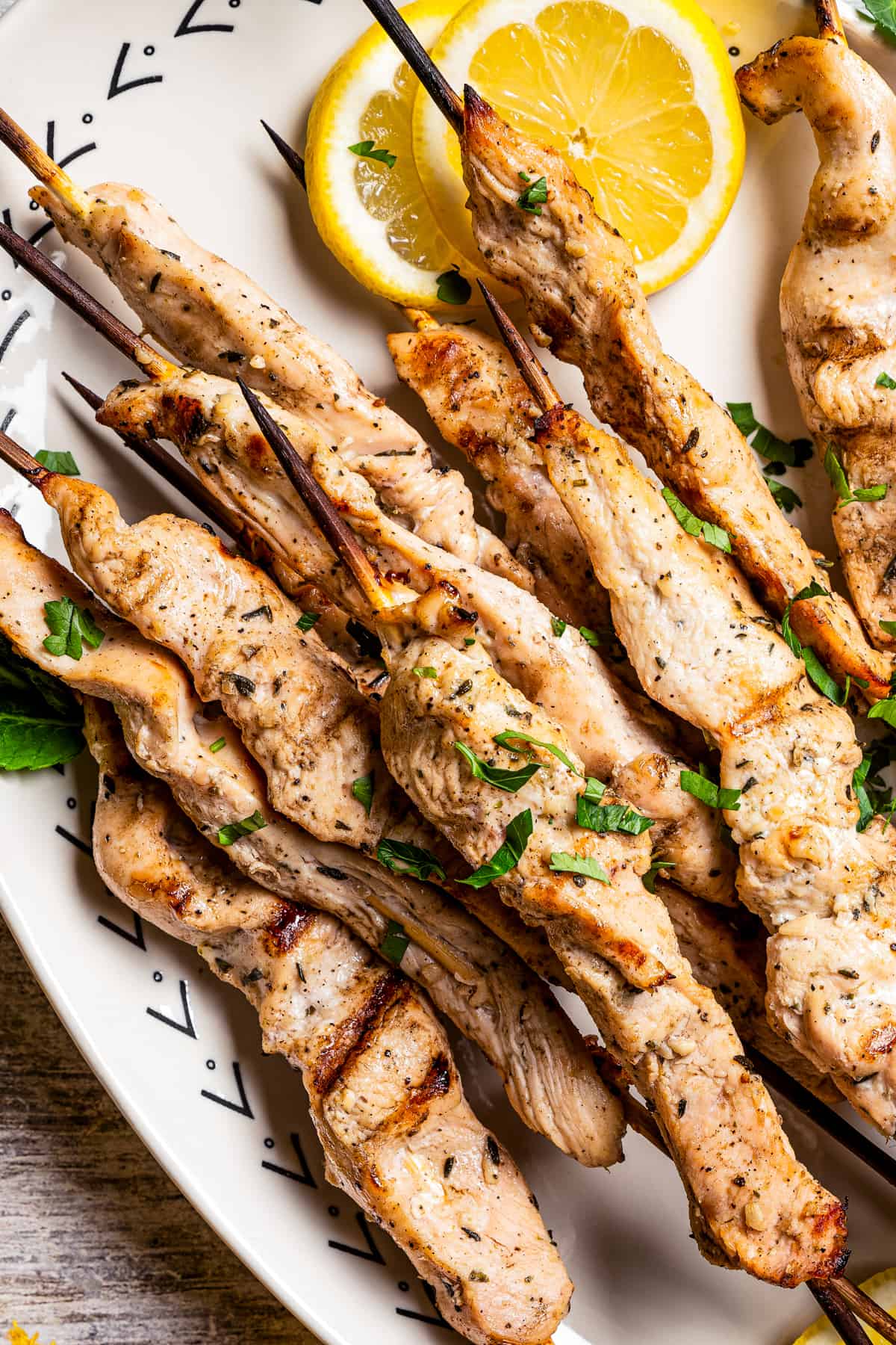 Up close shot of chicken skewers arranged on a serving platter.