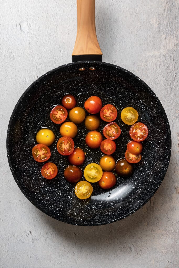 Blistering tomatoes in a pan.