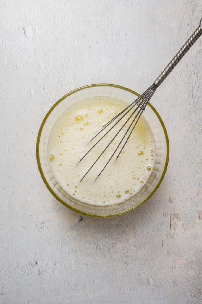 Whisking egg whites with salt and pepper.