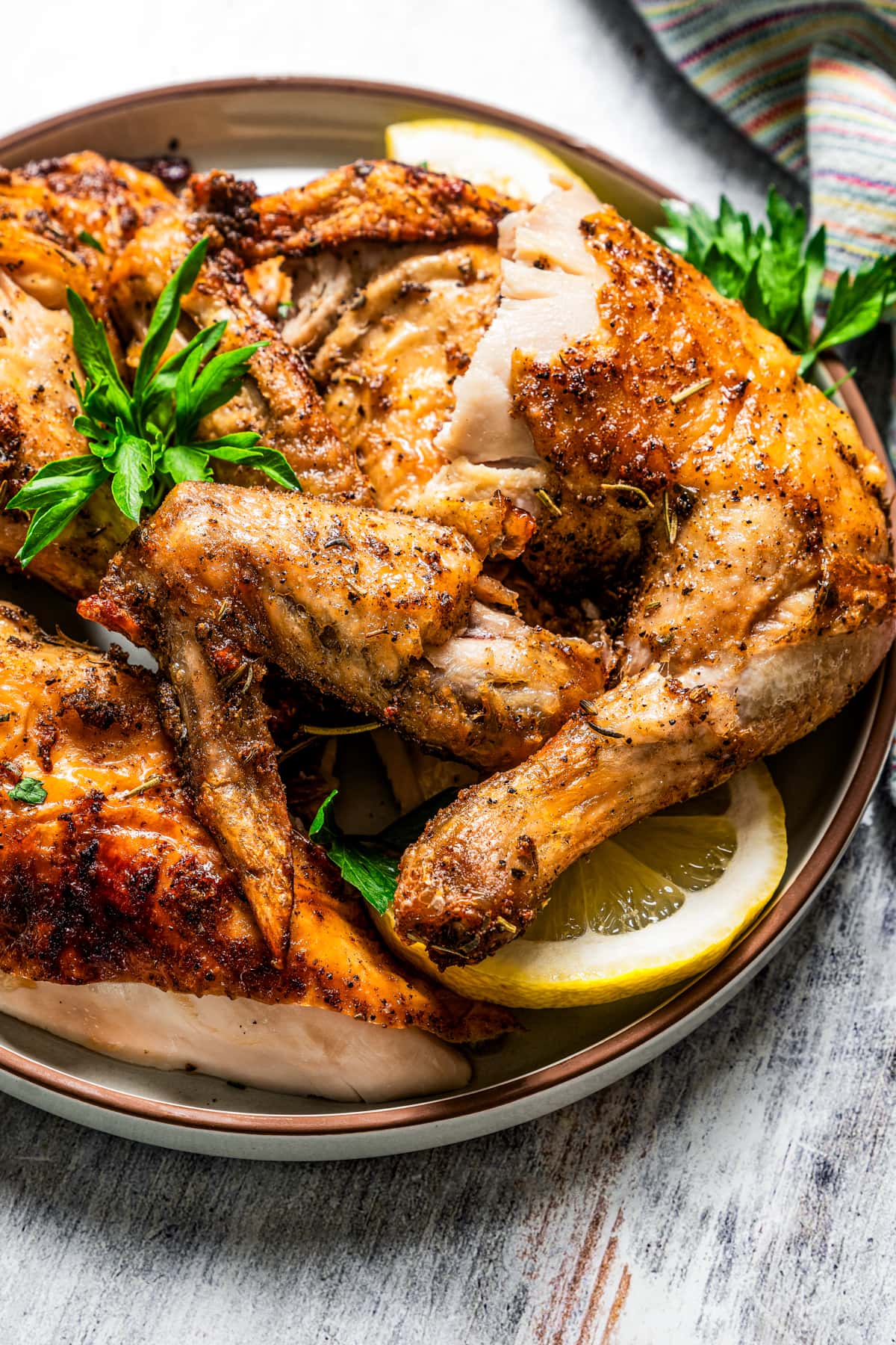 Air fryer rotisserie chicken cut into pieces and server on a plate.