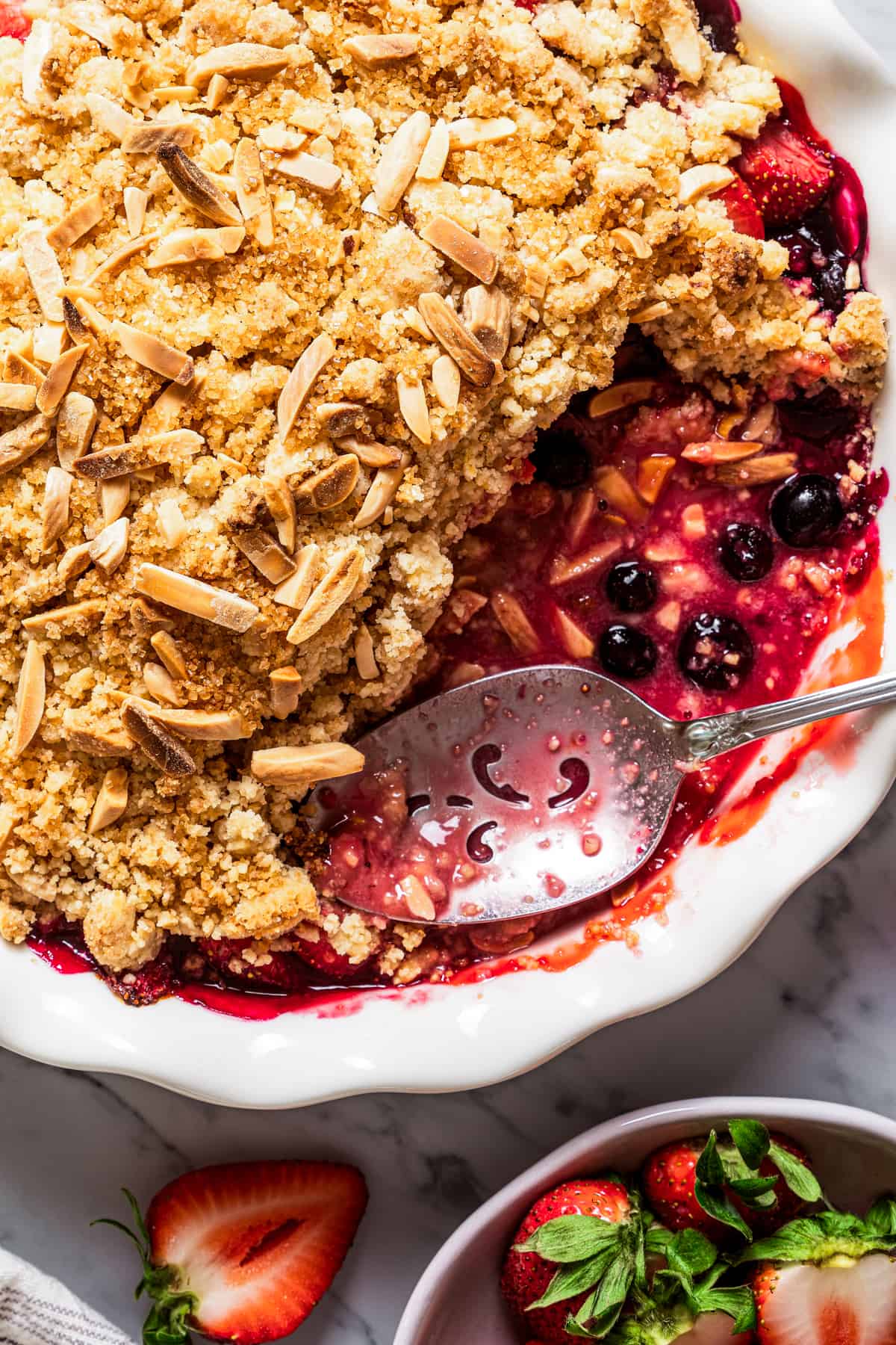 Close-up Strawberry Blueberry Crumble with a scoop of crumble taken out of the dish.