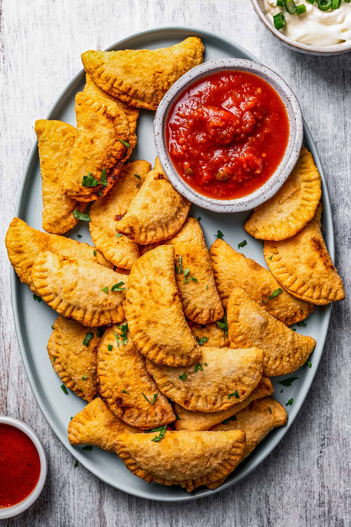 A plate with homemade Pierogi and dipping sauce.