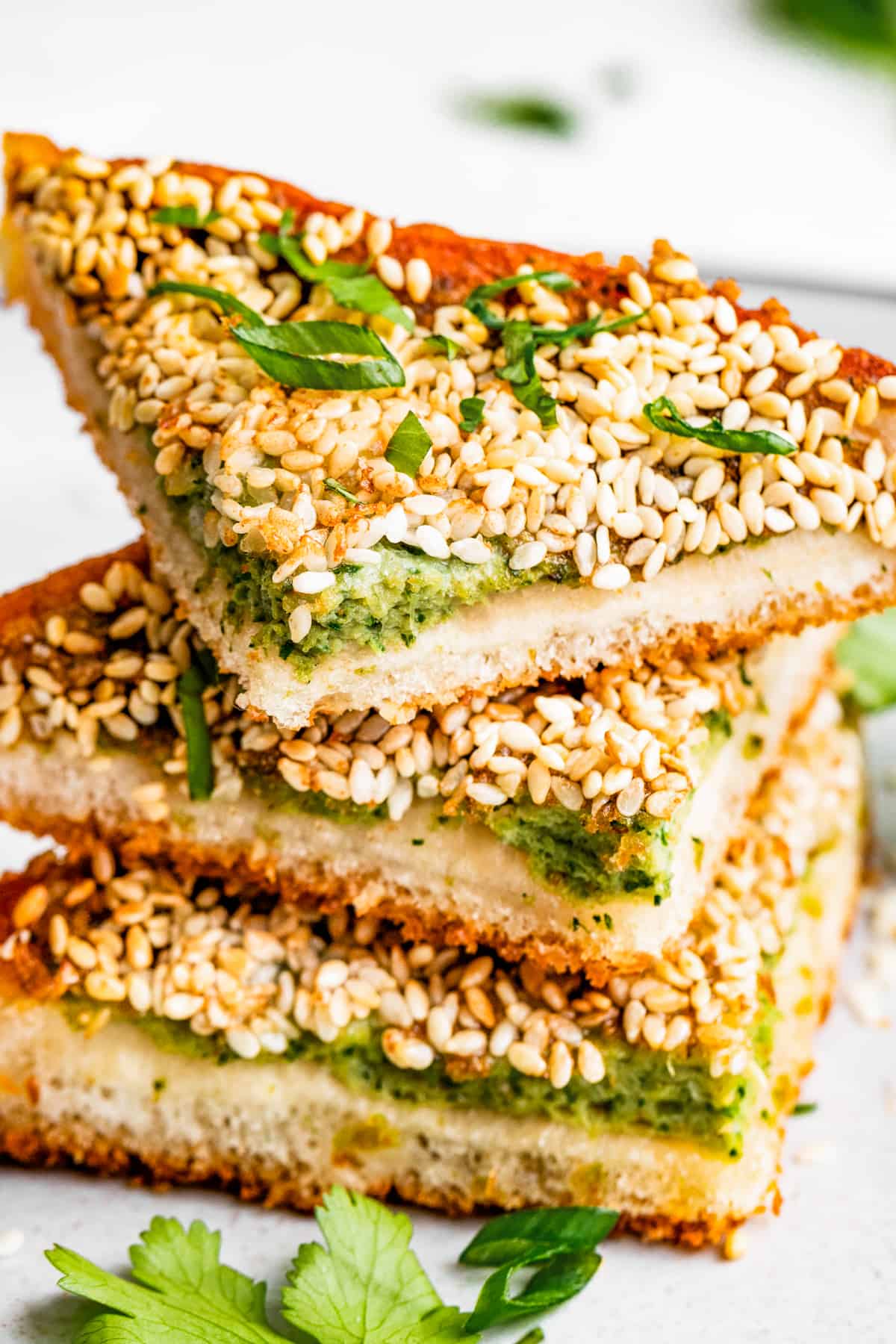 Close-up photo of shrimp toast triangles topped with sliced scallions.