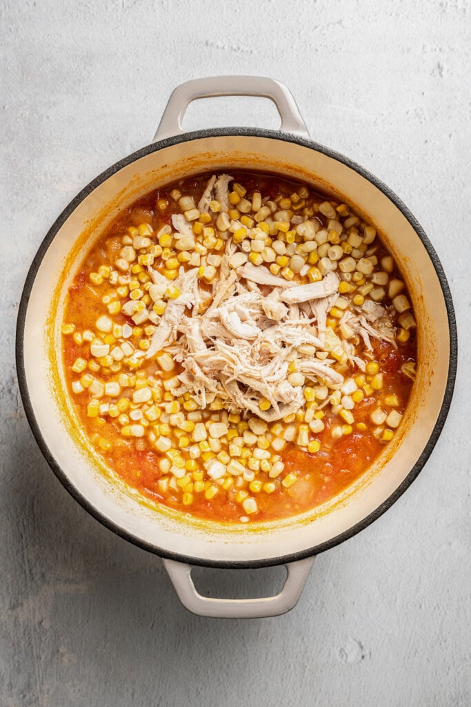 Adding chicken and corn to soup.