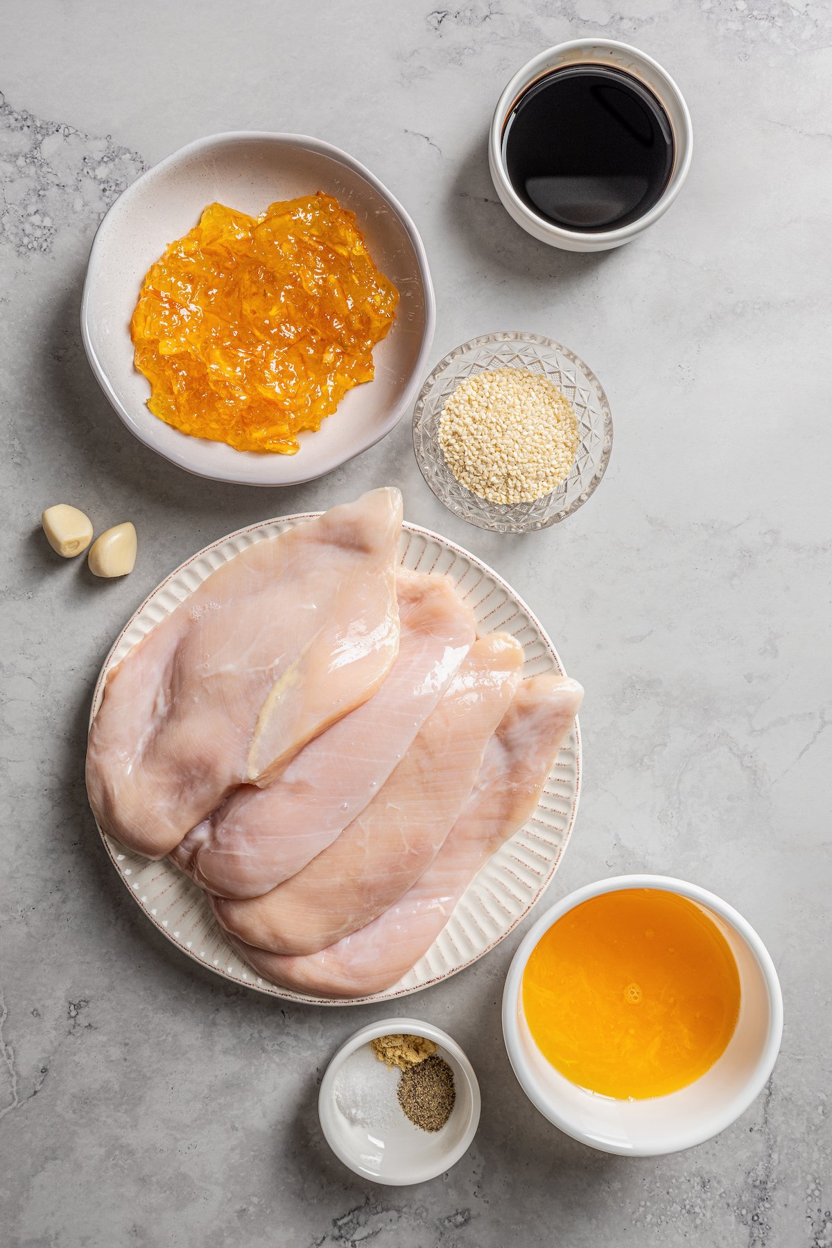 Ingredients for crockpot orange chicken separated into bowls.