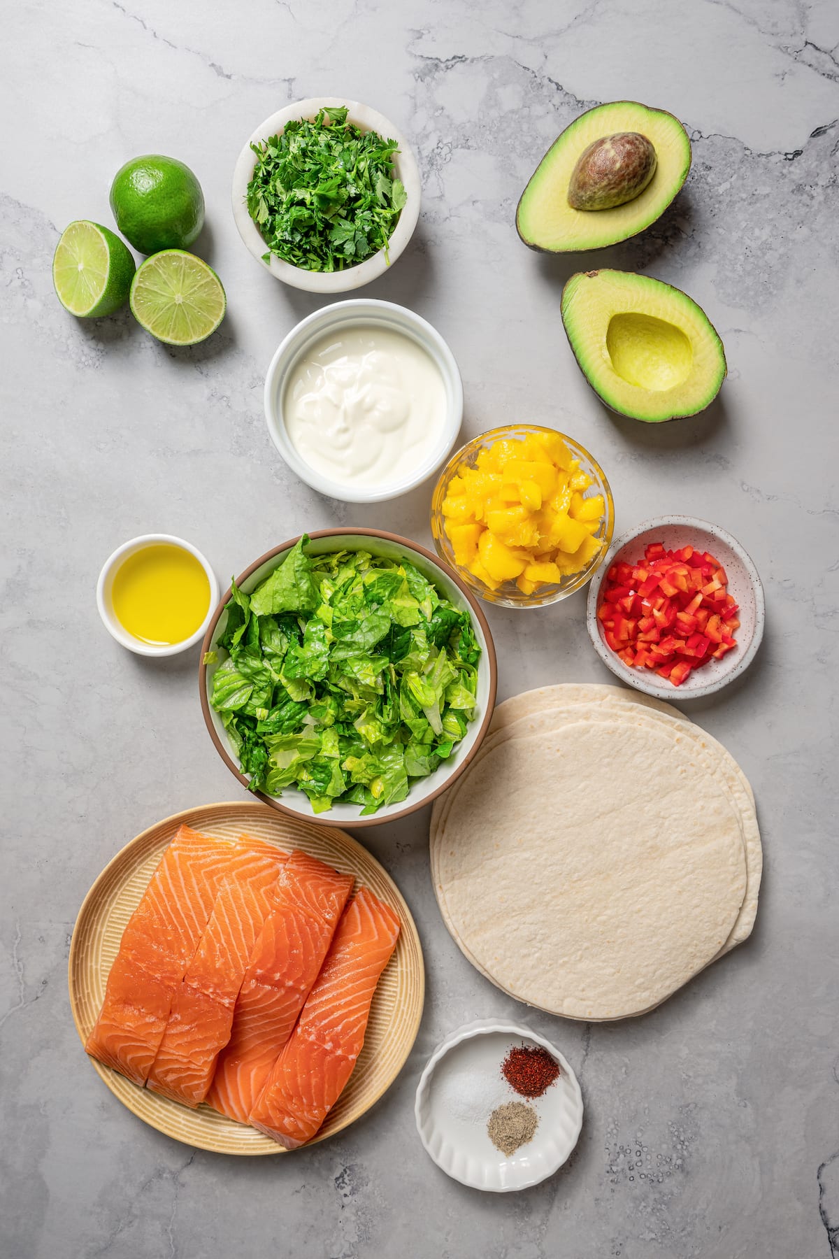 Ingredients for salmon tacos arranged on a work surface.