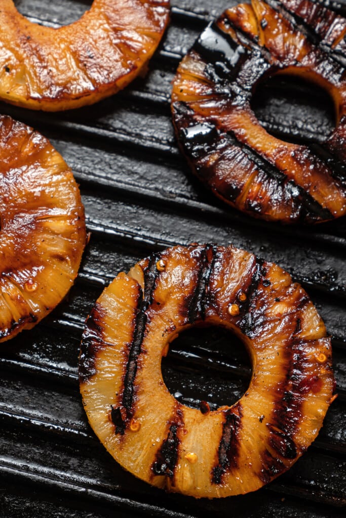 Grilled pineapple rings on a grill pan.
