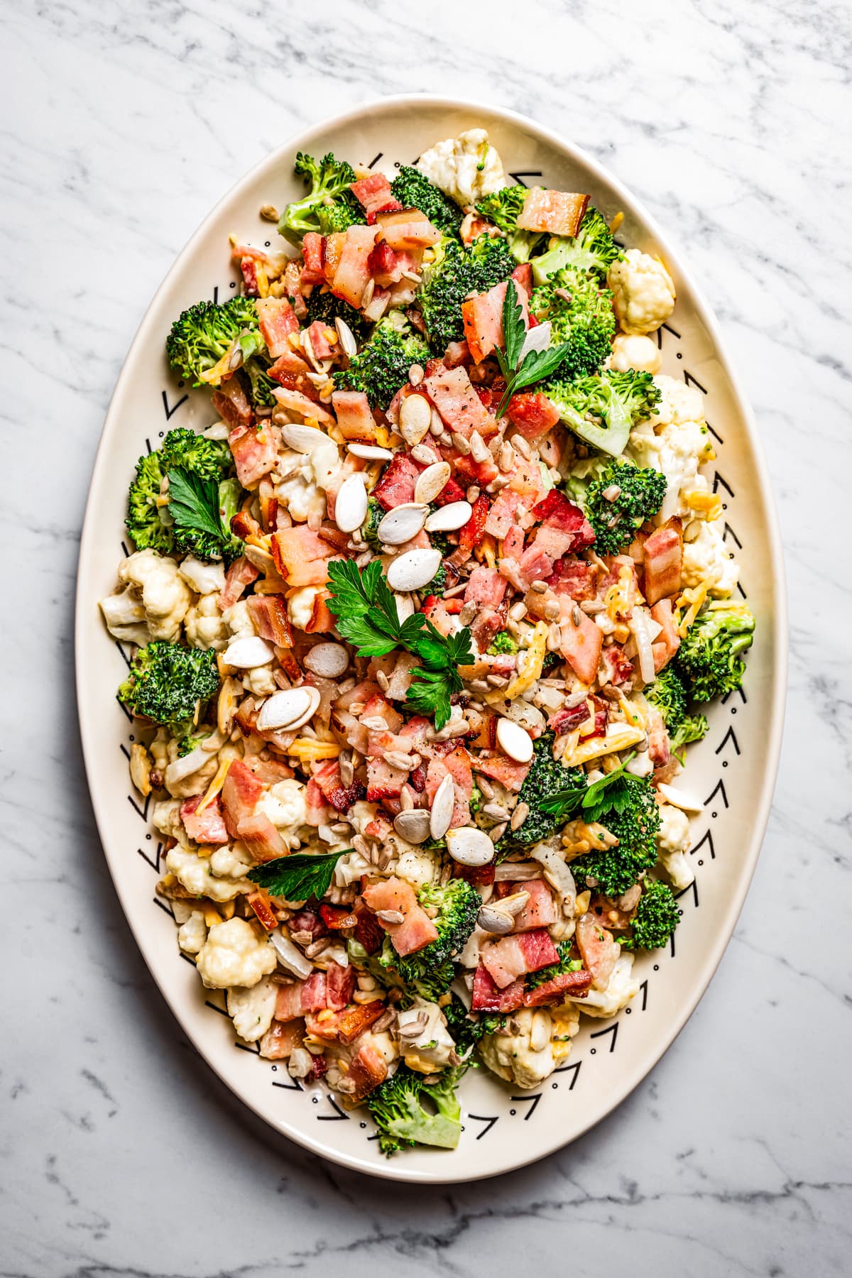 Overhead photo of broccoli cauliflower salad on a serving plate.