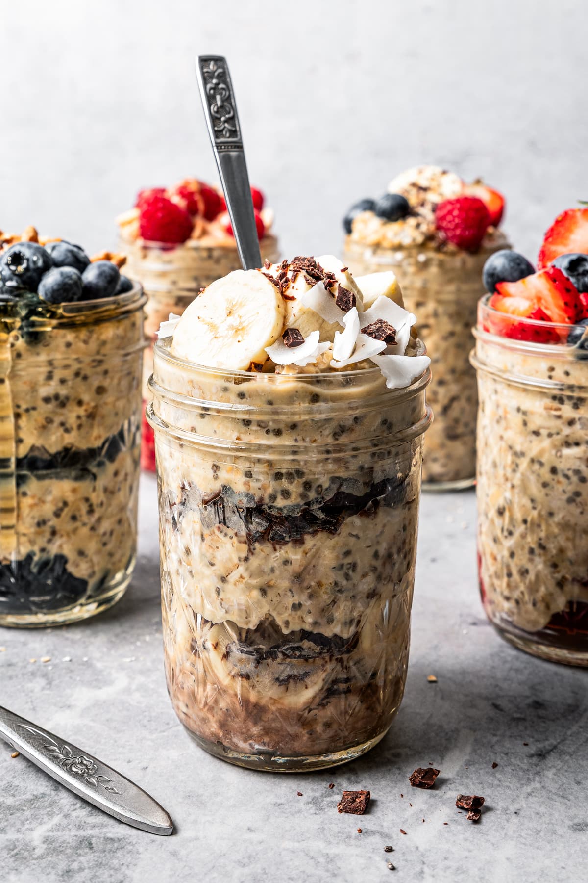 Photo of mason jars filled with protein oatmeal and topped with fruits.