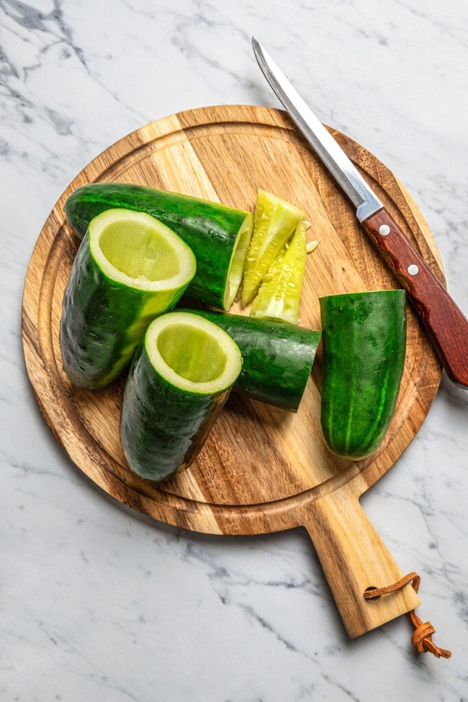 Hollowing out cucumbers with a knife.