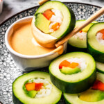 Dipping a slice of a cucumber roll in sriracha aioli.