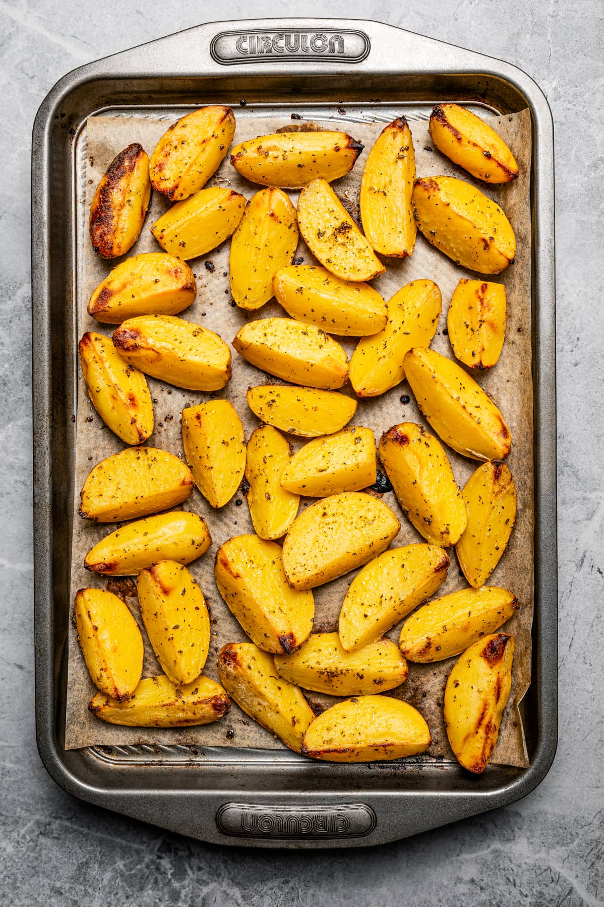 Roasted potato wedges on a sheet pan.
