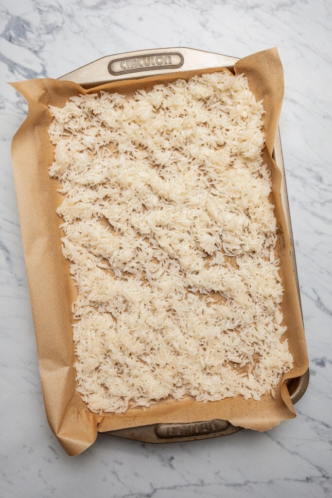 Drying cooked rice on a sheet pan.