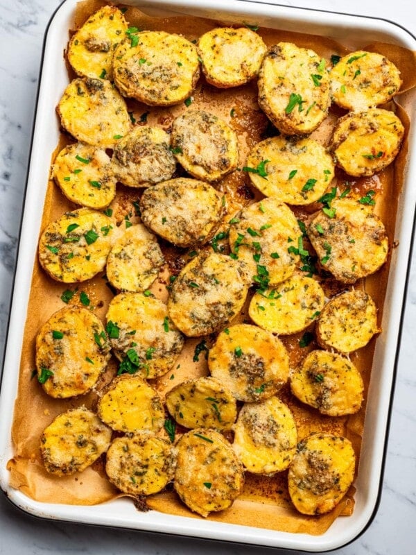 Overhead image of parmesan crusted potatoes arranged on a baking sheet.