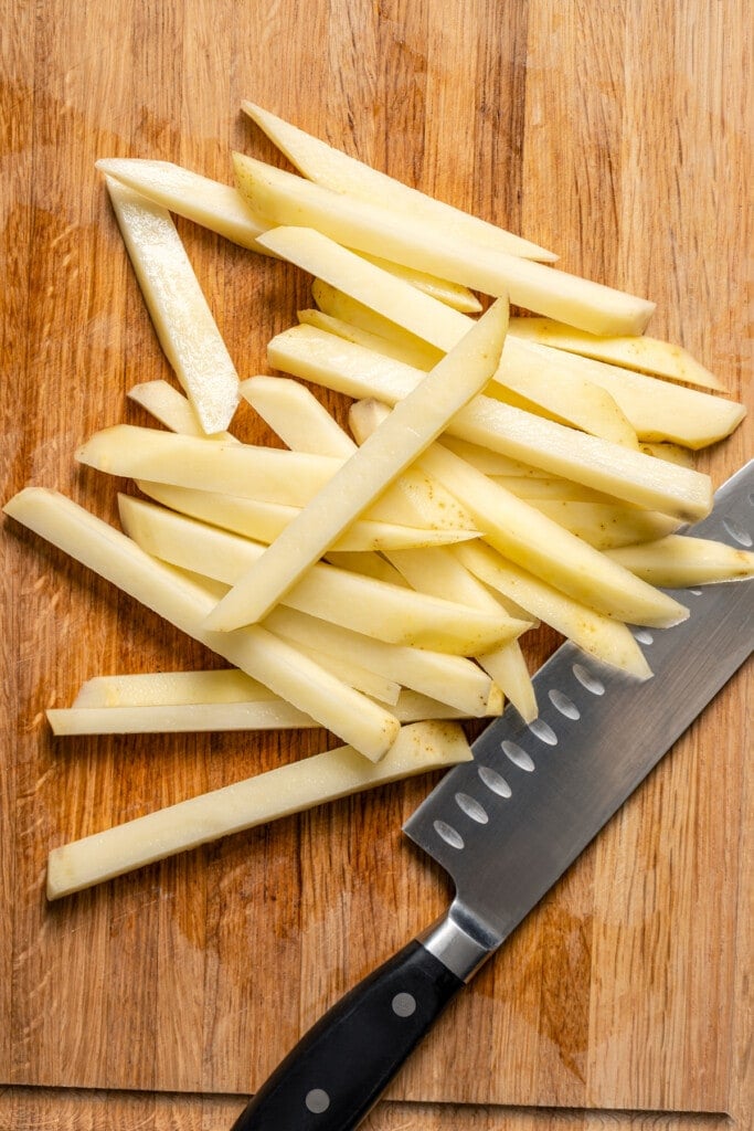 Cutting a potato into strips to make French fries.