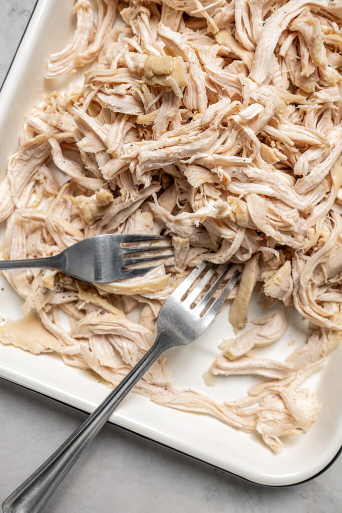 Shredding chicken with two forks.